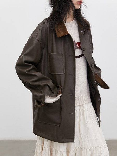 Oversized dark brown jacket worn over a light sweater and skirt