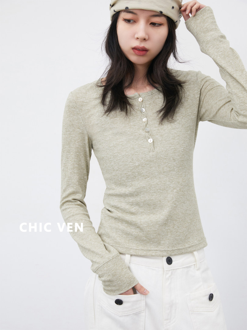 Woman wearing a light gray fitted long-sleeve top and white pants