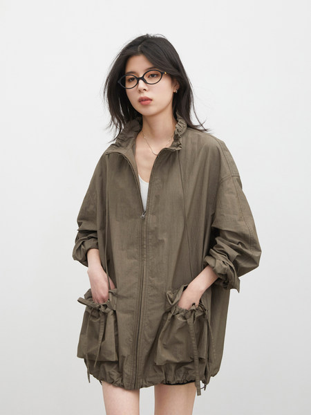 Model wearing an olive zip-up lightweight jacket with oversized pockets