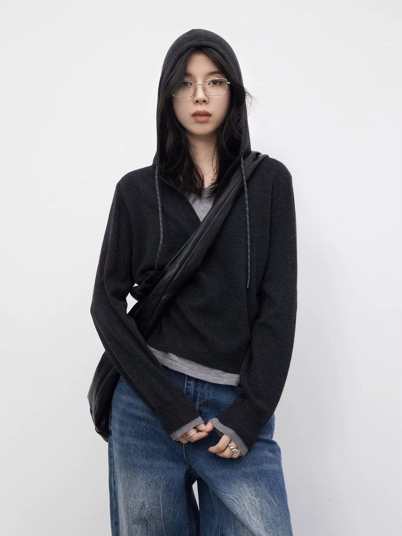 Model wearing a black hooded sweater with jeans and a crossbody bag