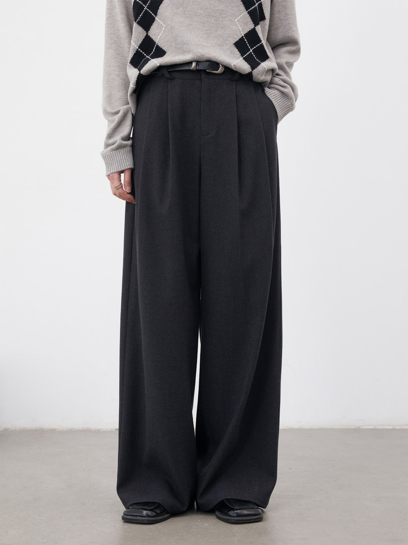 Model wearing black wide-leg trousers with a gray argyle sweater