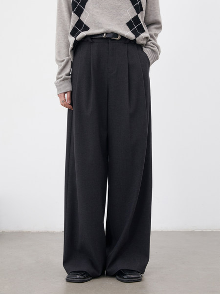 Model wearing black wide-leg trousers with a gray argyle sweater
