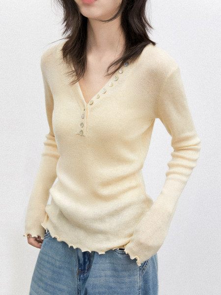 Model wearing a cream knit V-neck button-front long sleeve top