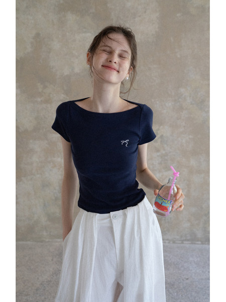 Model wearing a navy short-sleeve top with a white flowy skirt