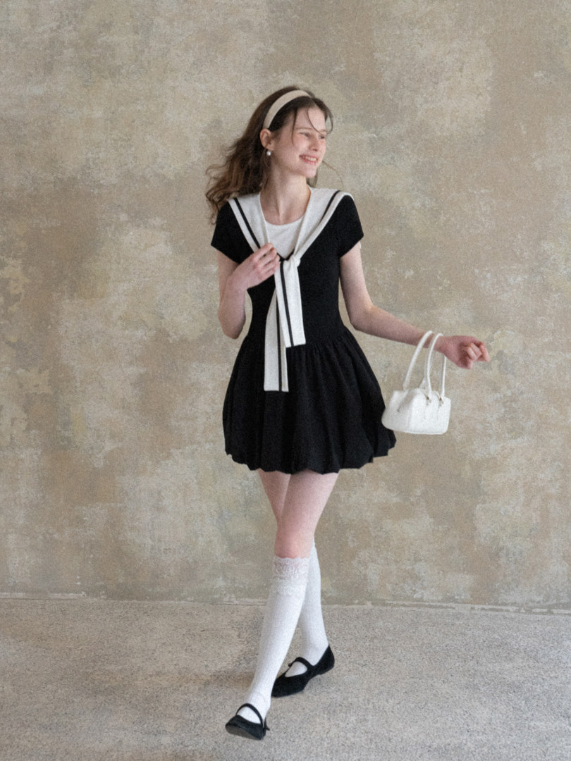 Black and white sailor-style dress worn by a model with matching headband and bag