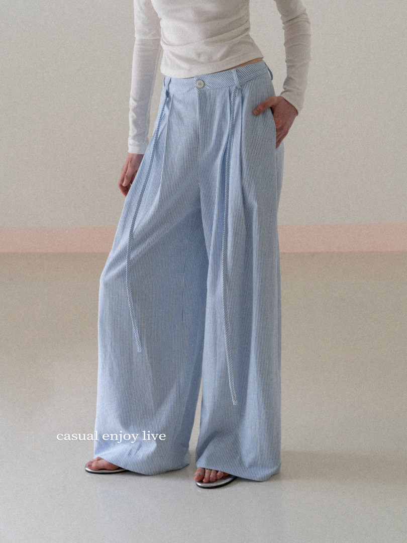 Model wearing light blue wide-leg striped pants with a white top