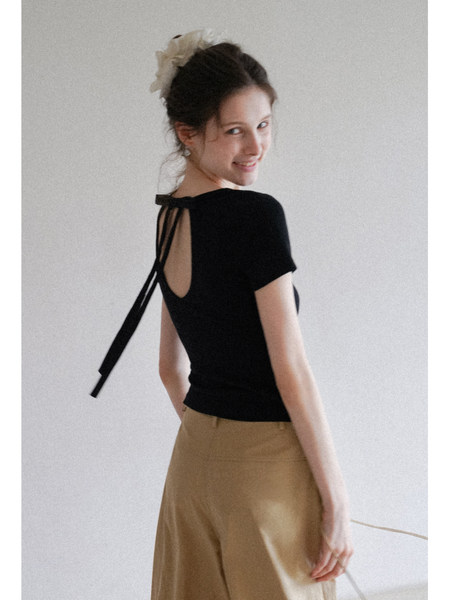 Black open-back short-sleeve top worn by a model