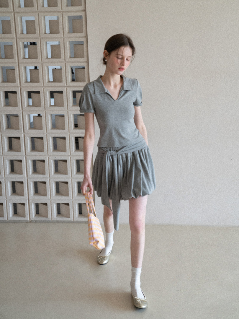 Grey two-piece outfit worn by a model with a short-sleeve top and skirt