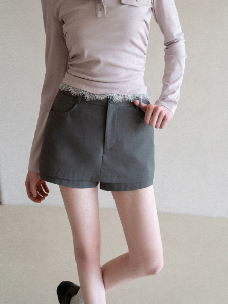 Model wearing dark gray shorts with a light long-sleeve top