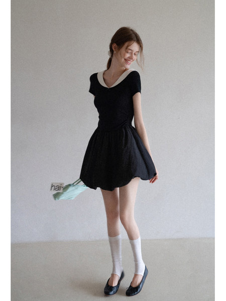 Black short-sleeve mini dress with a white collar worn by a model