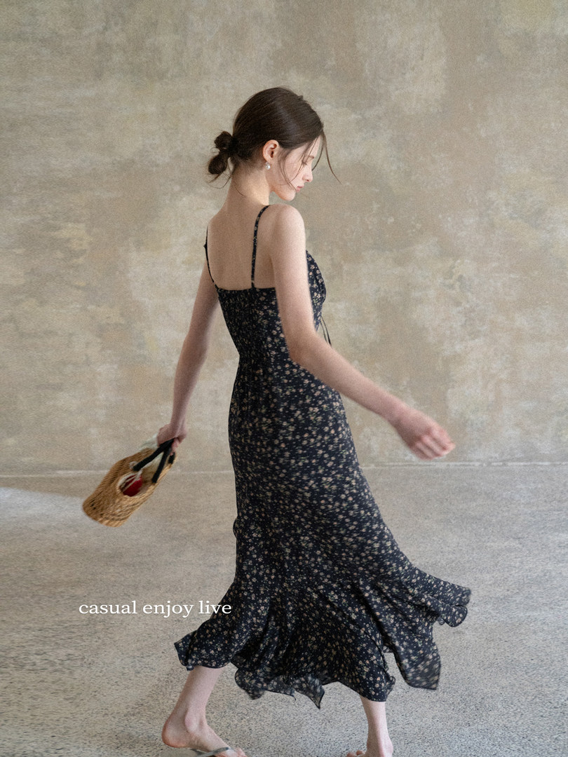 Woman wearing a black floral spaghetti-strap midi dress