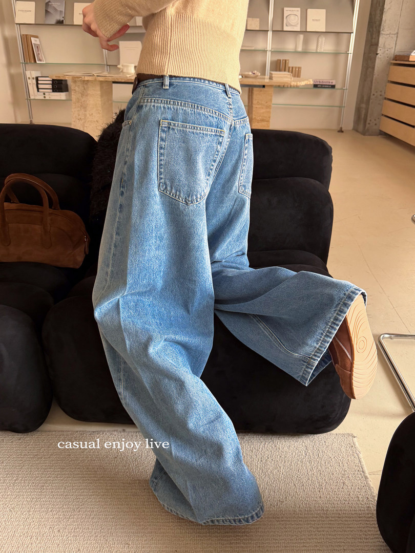 Person wearing light blue wide-leg denim jeans indoors