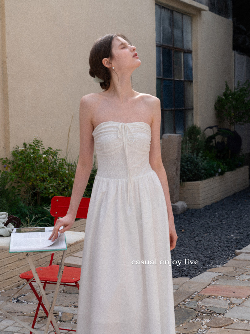 Woman wearing a white strapless maxi dress outdoors