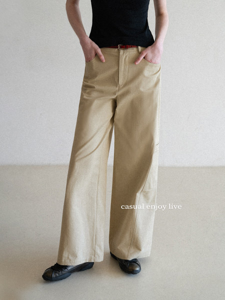 Model wearing beige wide-leg trousers with a black top and black shoes