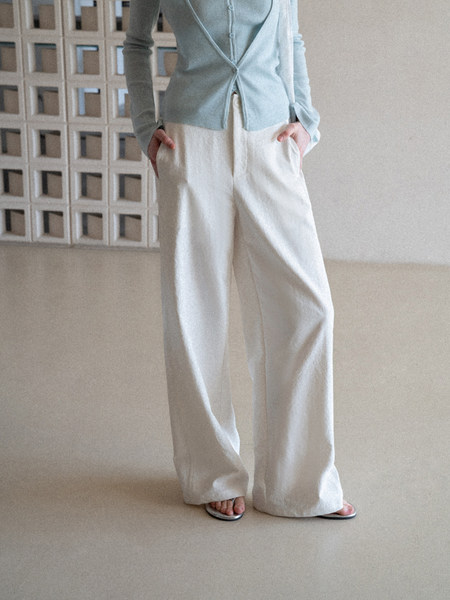Model wearing a light blue cardigan and white wide-leg pants