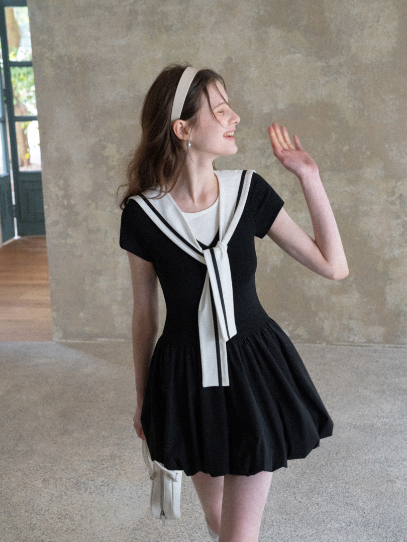 Black and white sailor-style dress worn by a model