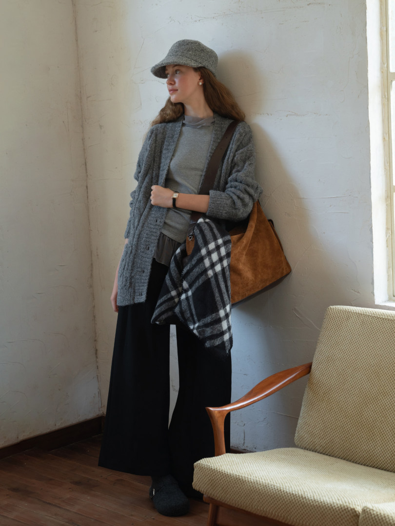 Model wearing a gray layered fall outfit with cardigan, cap, scarf, and shoulder bag