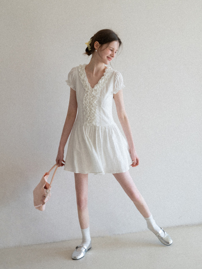 White ruffled short-sleeve mini dress worn by a model