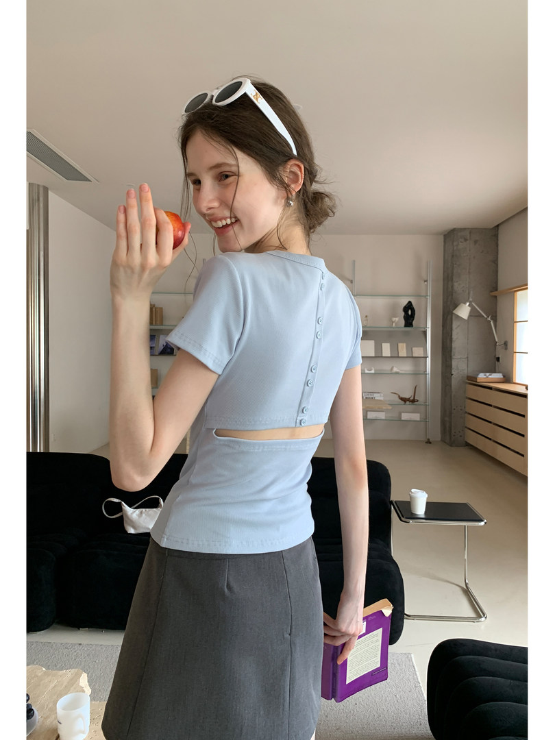 Model wearing a light blue short-sleeve crop top with a gray skirt