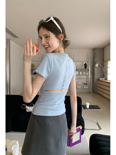 Model wearing a light blue short-sleeve crop top with a gray skirt
