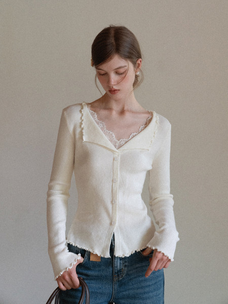 Model wearing a cream ribbed long-sleeve cardigan top with lace trim