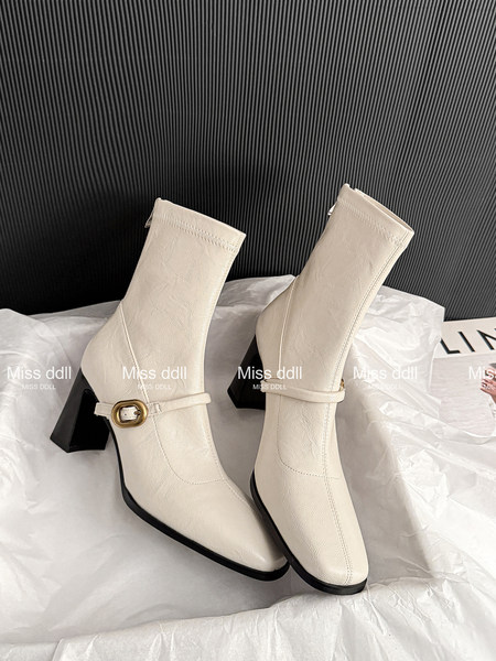 Pair of cream heeled ankle boots with buckle detail