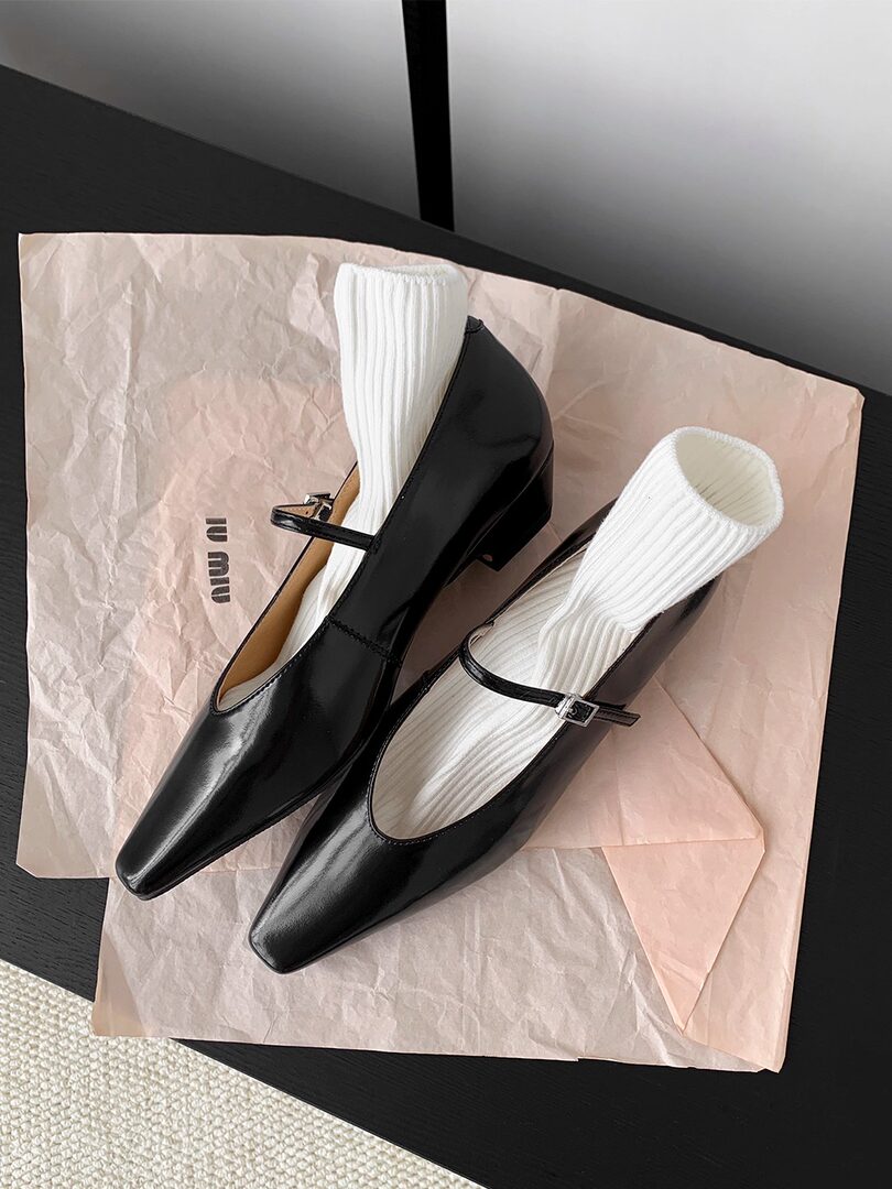 Black pointed-toe Mary Jane low-heel shoes on tissue paper
