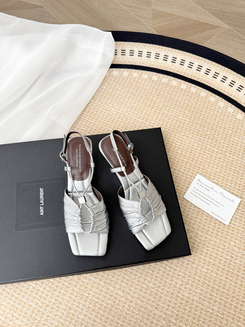 Silver strappy heeled sandals displayed on a branded shoebox