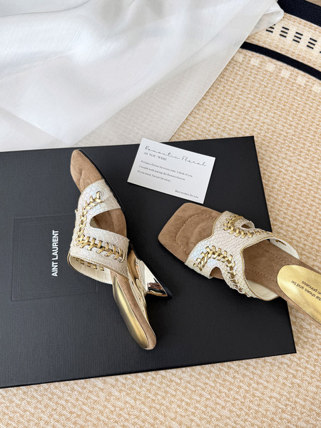 Pair of embellished gold-and-white heeled sandals on a branded box
