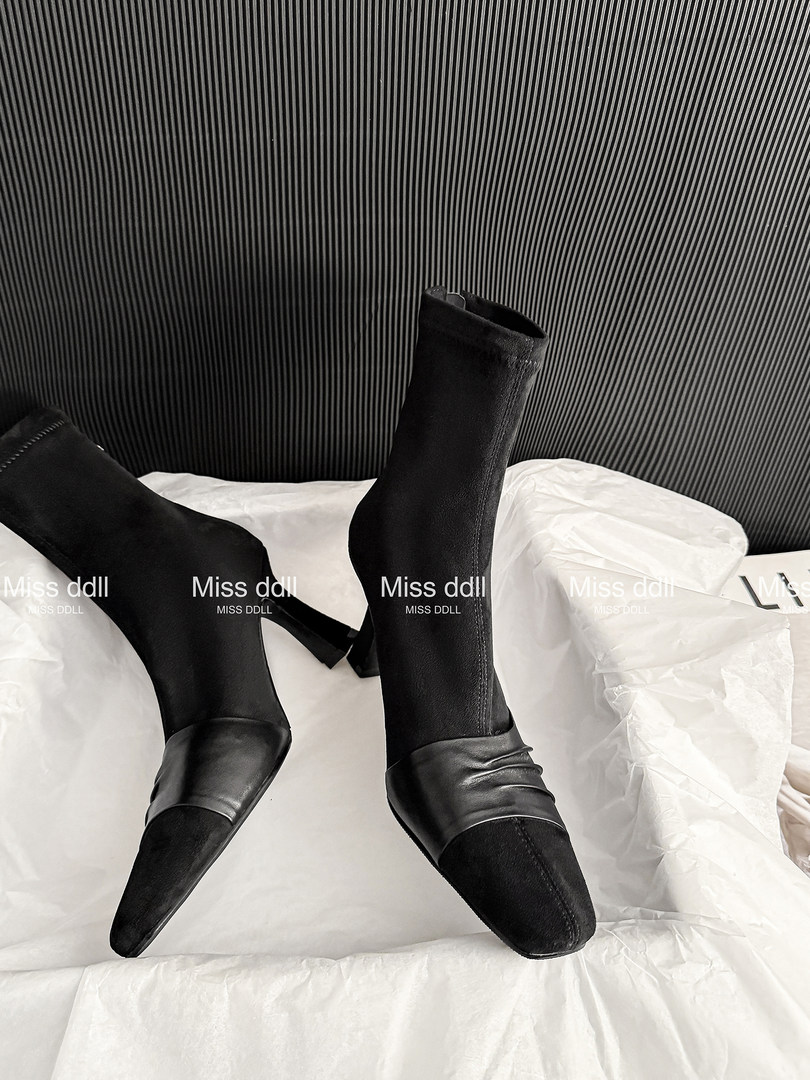 Black pointed-toe high-heel ankle boots displayed on white packaging