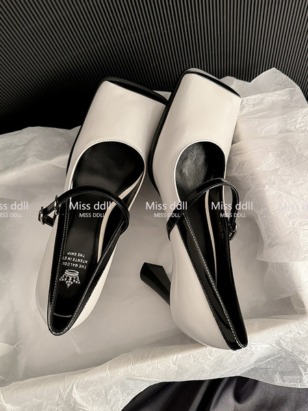 Black and white heeled slingback pumps displayed on fabric