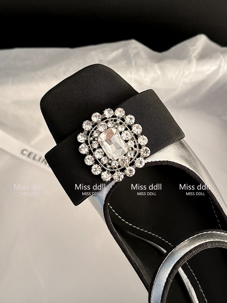 Black sandal with a jeweled decorative buckle on the strap