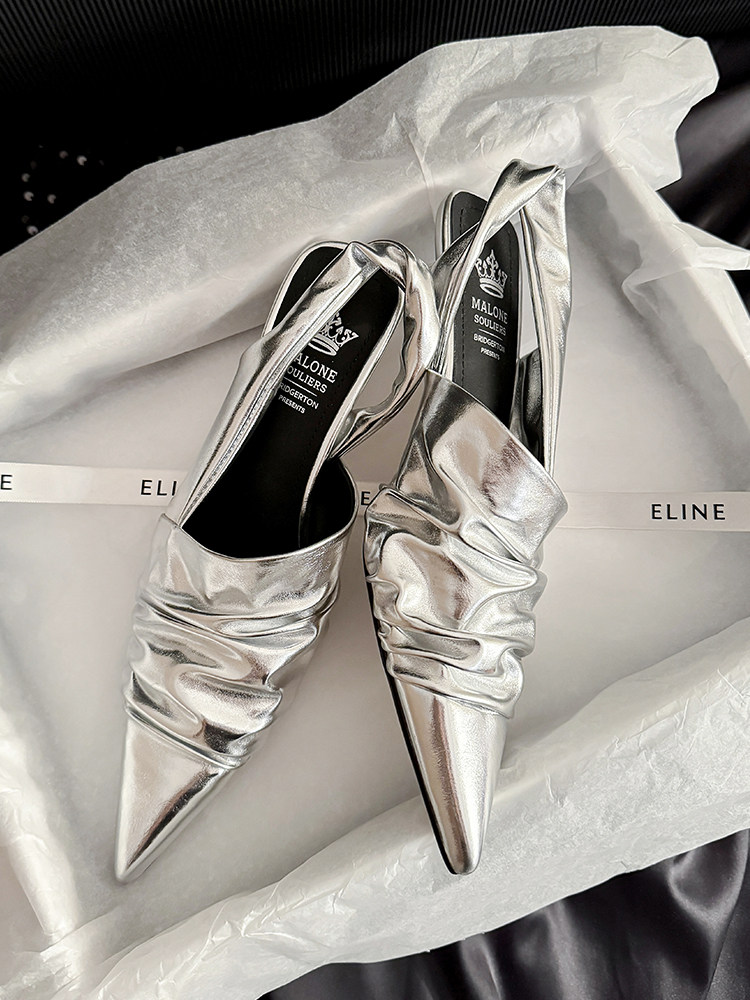 Silver metallic pointed-toe heeled slingback shoes on tissue paper