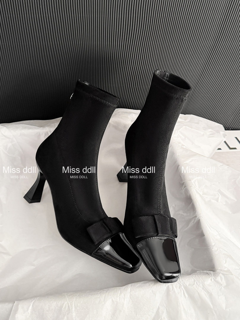 Black pointed-toe heeled ankle boots with glossy toe caps
