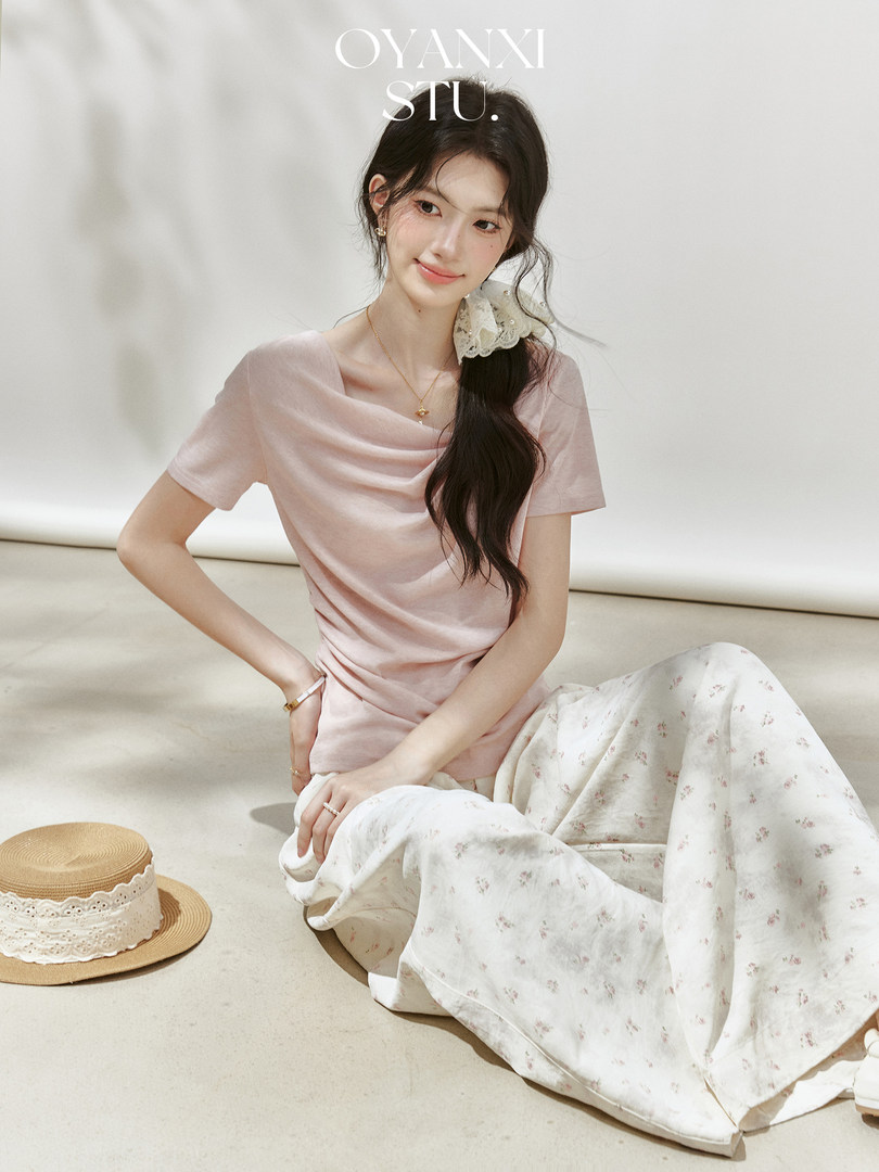 Model wearing a light pink short-sleeve top and a white floral skirt