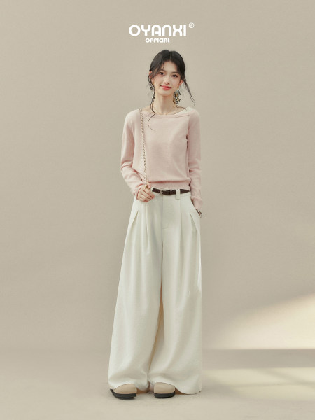 Model wearing a light pink sweater with cream wide-leg pants