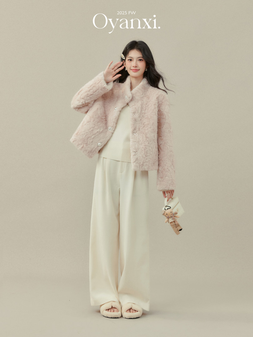 Model wearing a pale pink faux fur jacket with cream wide-leg pants and slippers