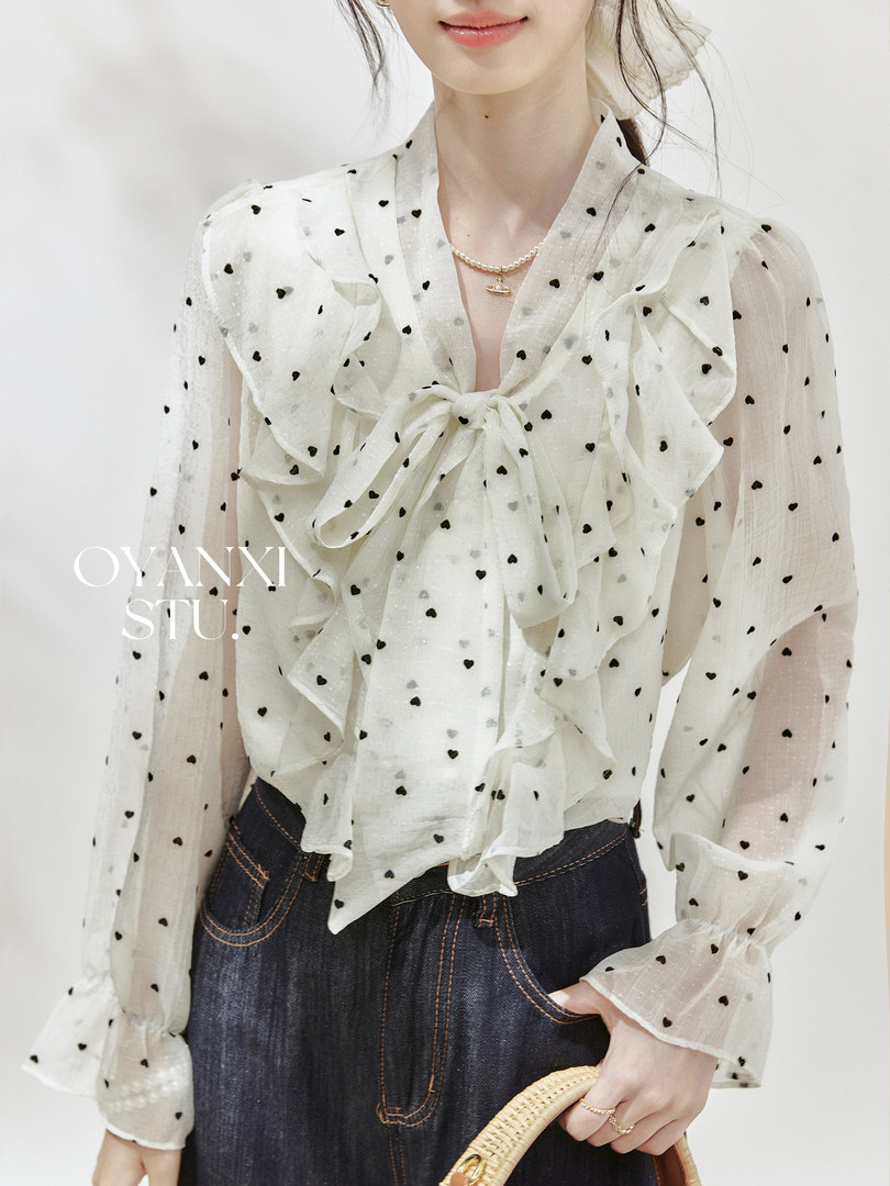 White sheer heart-print long-sleeve blouse worn by a model