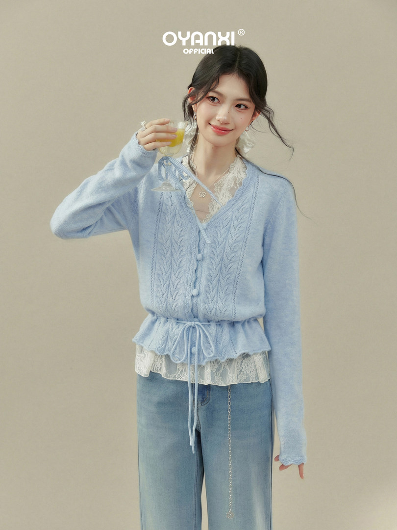 Model wearing a light blue knit cardigan over a lace-trim top with jeans