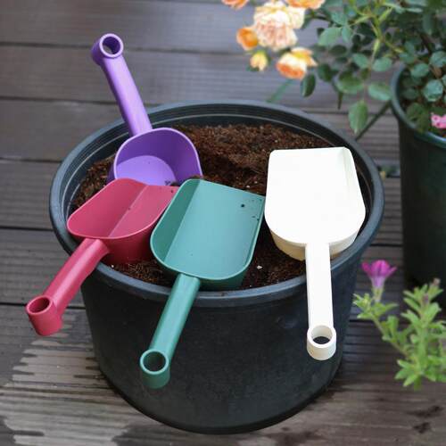 Gardening tools, including a thick plastic soil shovel, cat