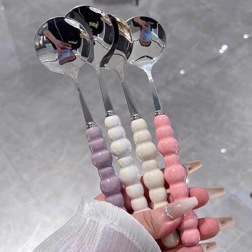 Trendy pearl-colored stainless steel spoon with a plastic ha
