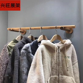 服装店上墙壁挂展示架木棍，衣杆侧挂女装，陈列墙上置衣架童装店货架