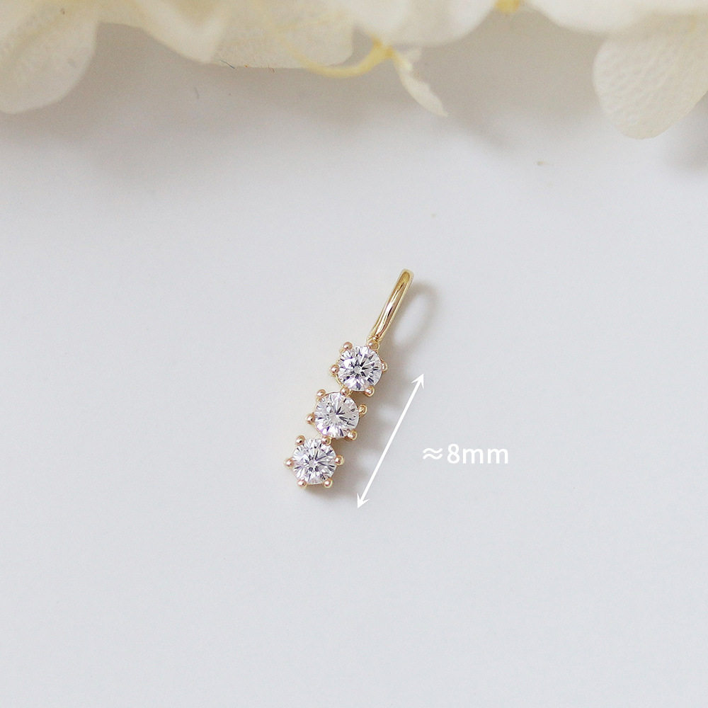 9k gold A small pendant with three diamonds in a single vertical bar