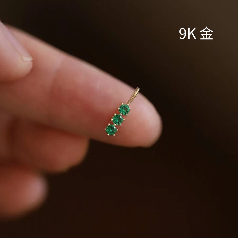 9k gold A small pendant with three diamonds in a single vertical bar