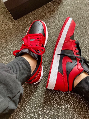 Корова погашает Air Jordan 1 низкий AJ1, реверсирует и носит черный красный носок с низким верхом 553558-606