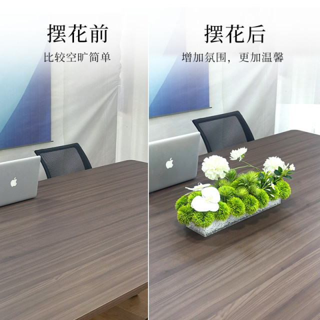 Conference table with flowers and green plants in the middle of the long table in the conference room