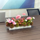 Conference table with flowers and green plants in the middle of the long table in the conference room