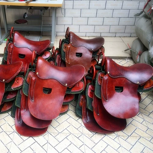 Вся ретро и практическая обстановка седла, демонстрируя декоративный набор украшений и табуреток, овощной загорелой кожи