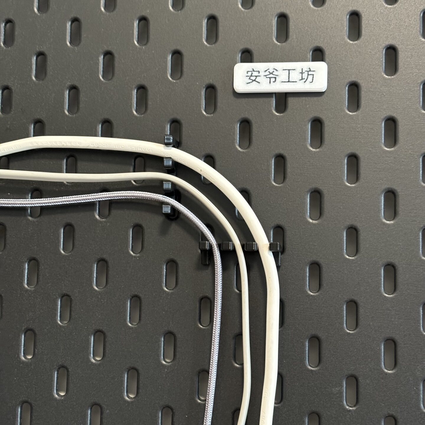 Cable organizer bracket adapts to IKEA perforated plate