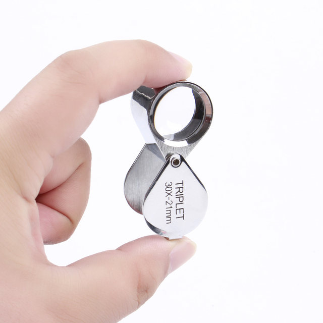 Appraisal of gemstones by looking at diamond girdle size magnifying glass Baister